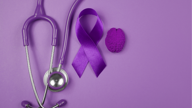 Purple stethoscope, awareness ribbon, and brain symbol on a purple background representing menopause awareness and midlife health support.
